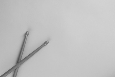 Photo of Two gray drum sticks on light background, top view. Space for text