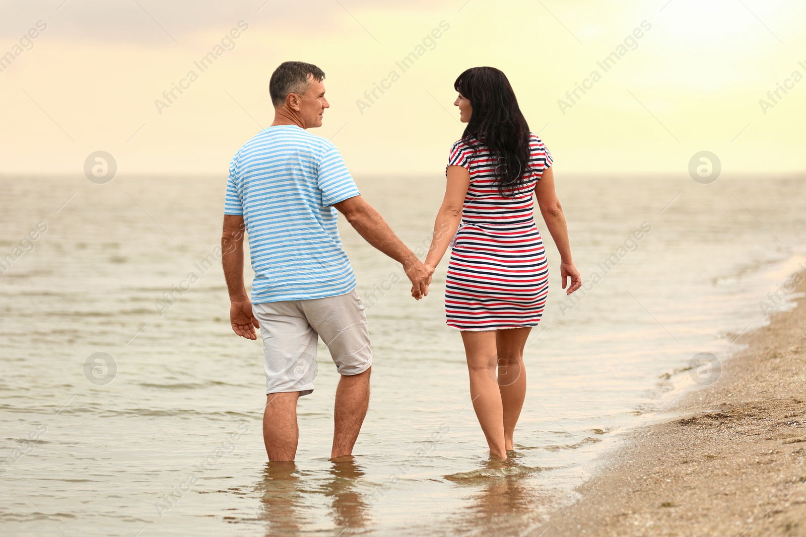 Photo of Happy mature couple walking together on sea beach