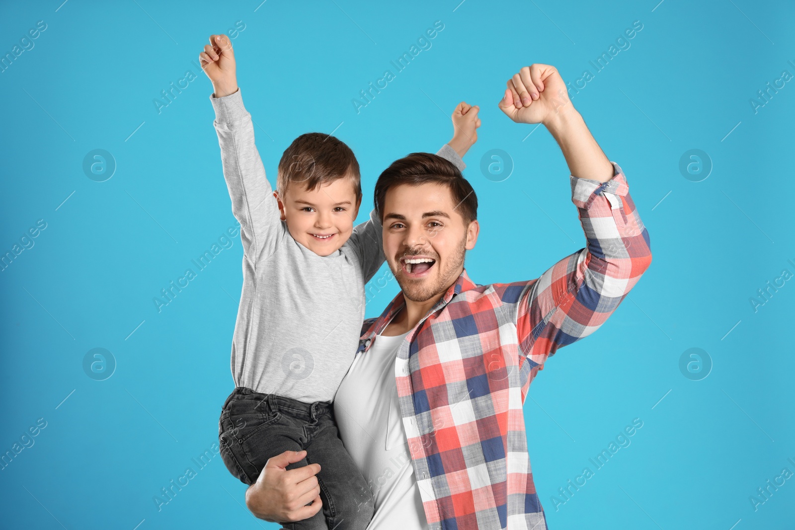 Photo of Portrait of emotional dad and his son on color background