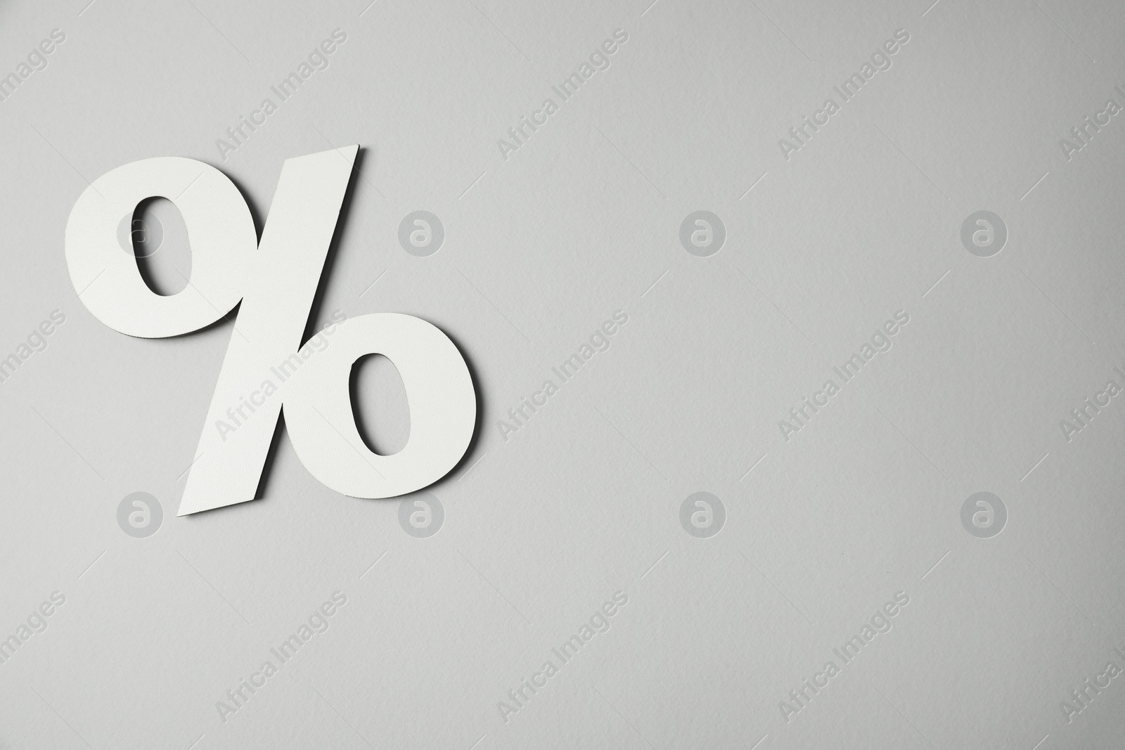 Photo of White percent sign on light grey background, top view. Space for text