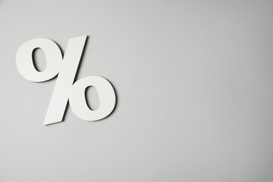 Photo of White percent sign on light grey background, top view. Space for text