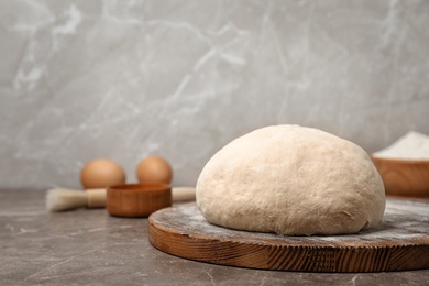 Photo of Fresh raw dough ball on wooden board