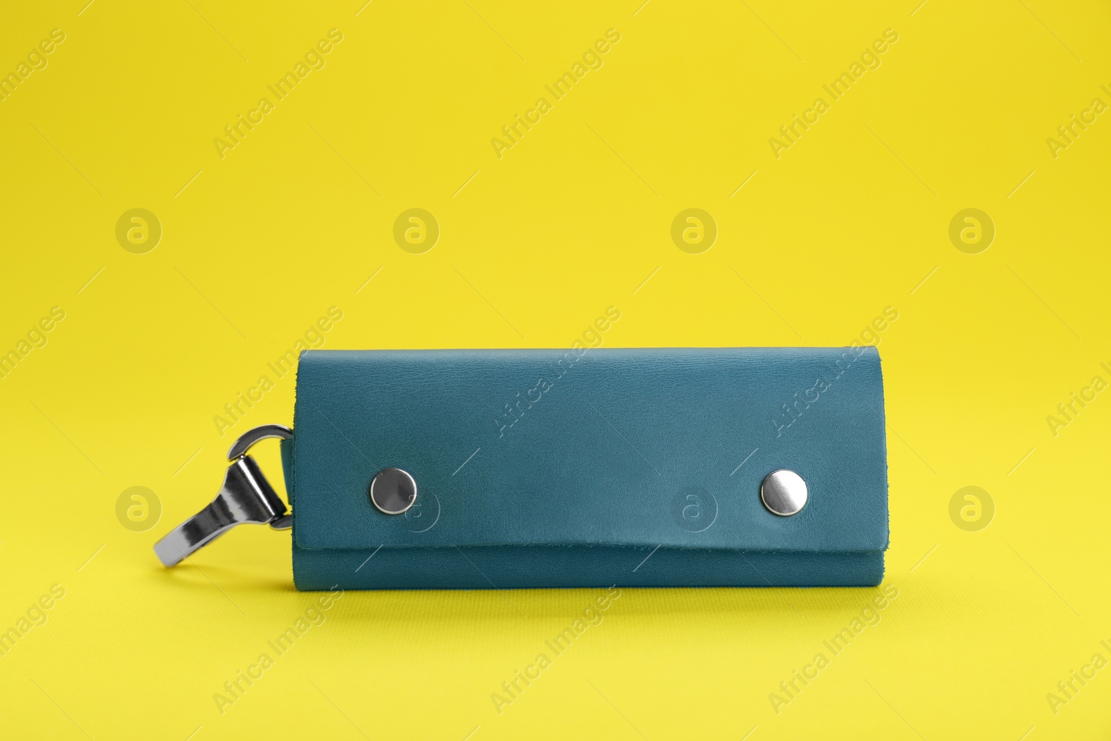 Photo of Stylish leather keys holder on yellow background