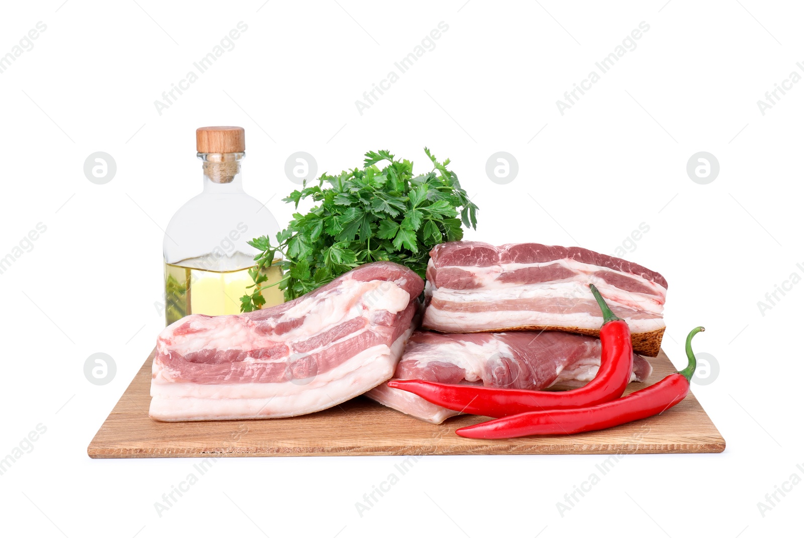 Photo of Pieces of raw pork belly, parsley, chili peppers and oil isolated on white