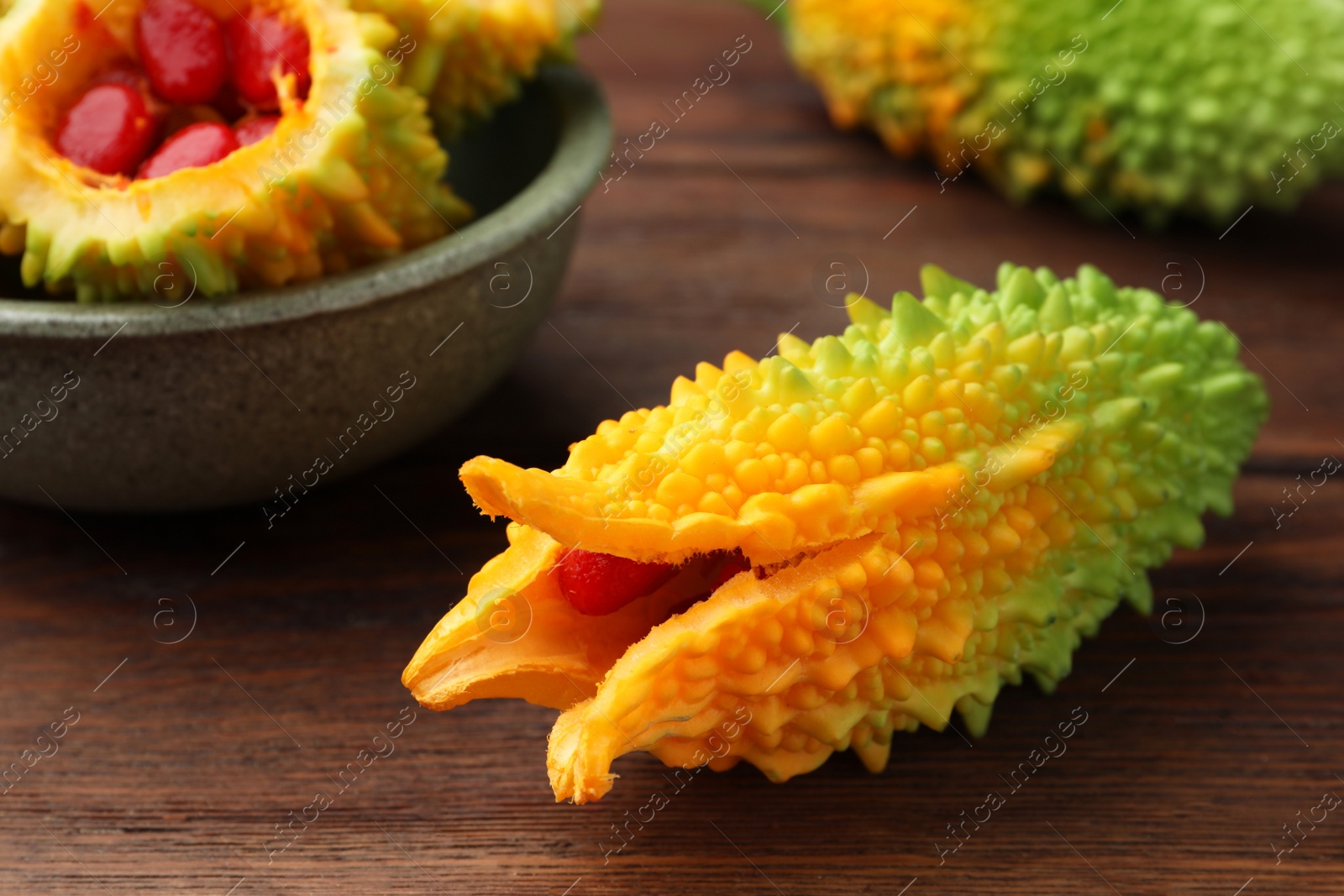 Photo of Many fresh bitter melons on wooden table, closeup