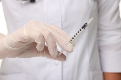 Photo of Doctor holding medical syringe with needle, closeup view