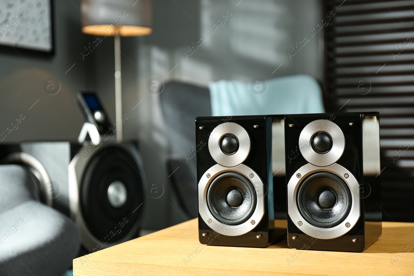 Photo of Modern audio speaker system on wooden table in living room