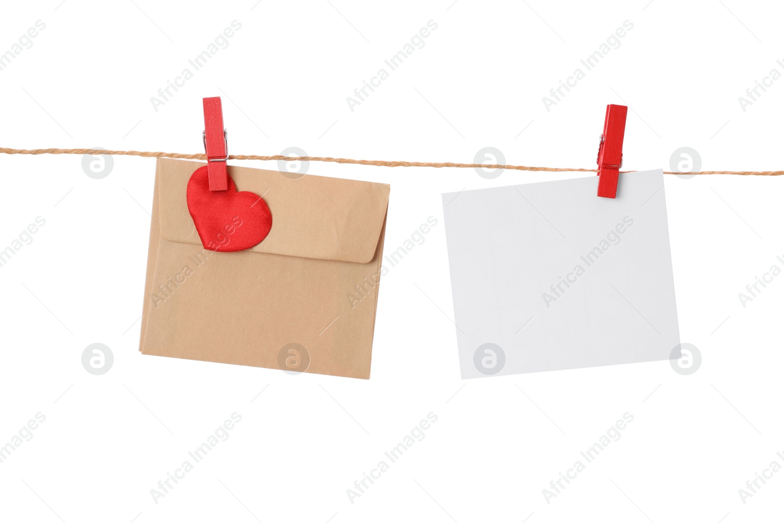 Photo of Blank card and envelope hanging on twine against white background. Valentine's Day celebration