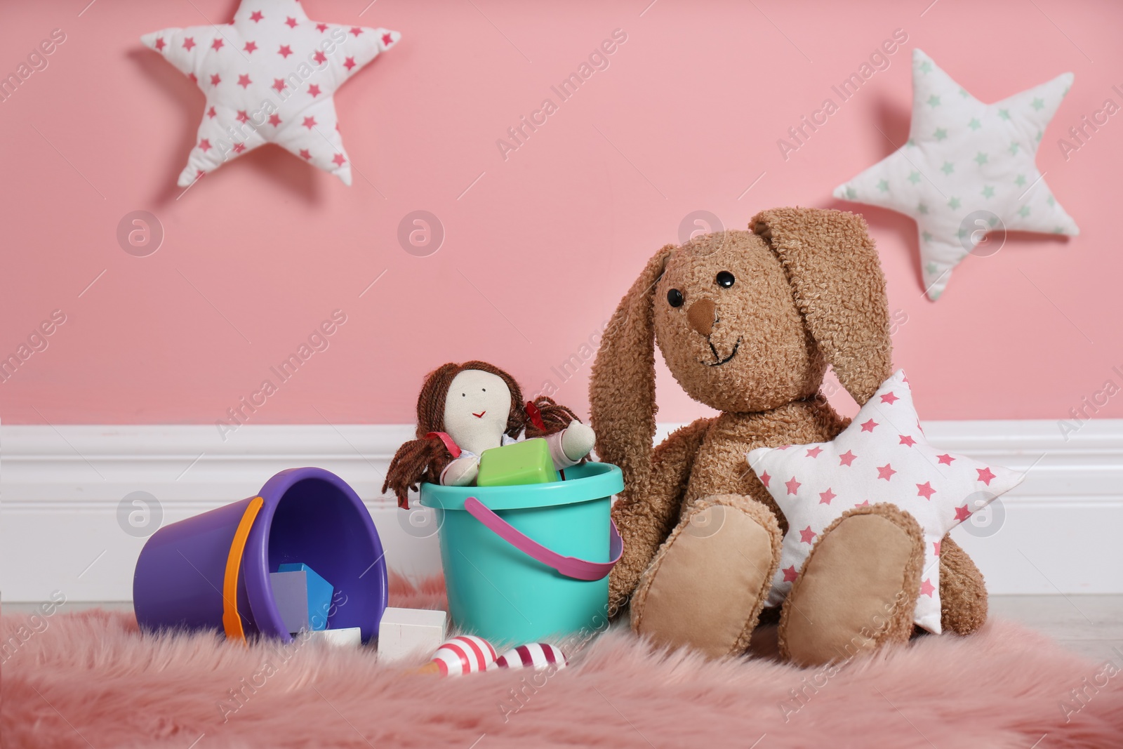 Photo of Set of different child toys on floor against color wall