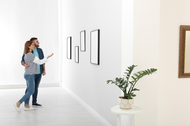 Photo of Couple viewing exposition in modern art gallery