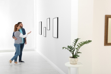 Couple viewing exposition in modern art gallery