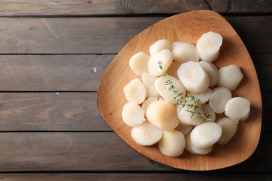 Photo of Fresh raw scallops and thyme on wooden table, top view. Space for text
