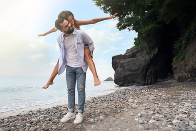 Photo of Happy young couple having fun on beach sea. Space for text