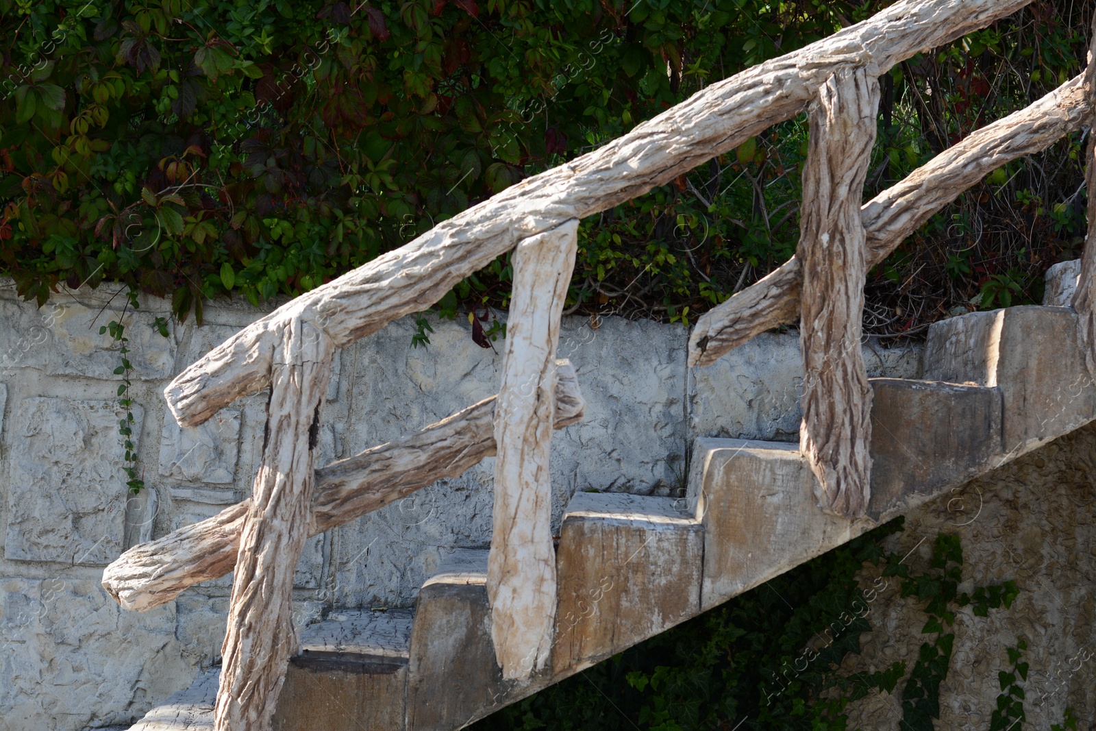 Photo of View of empty old staircase with wooden railing outdoors on sunny day