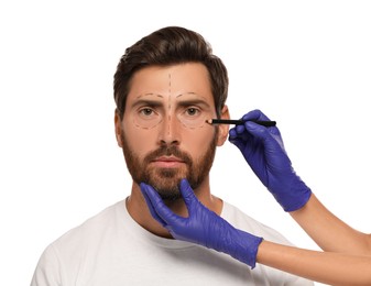 Photo of Doctor with pencil preparing patient for cosmetic surgery operation on white background