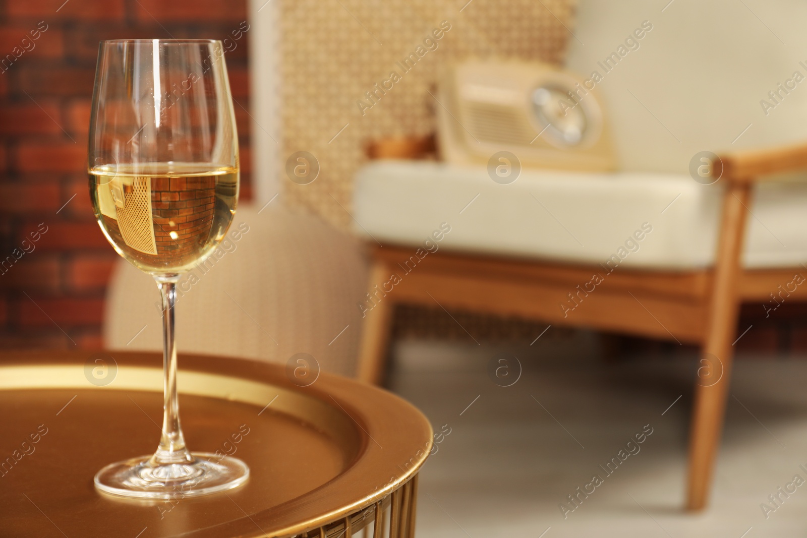 Photo of Glass of white wine on table in room, space for text. Relax at home