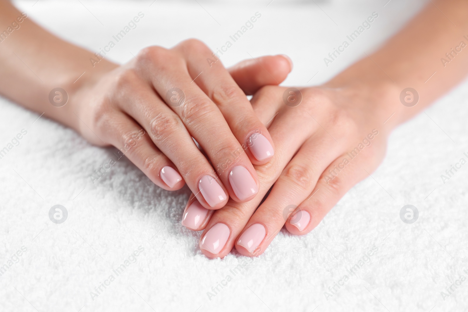 Photo of Closeup view of beautiful female hands on towel. Spa treatment