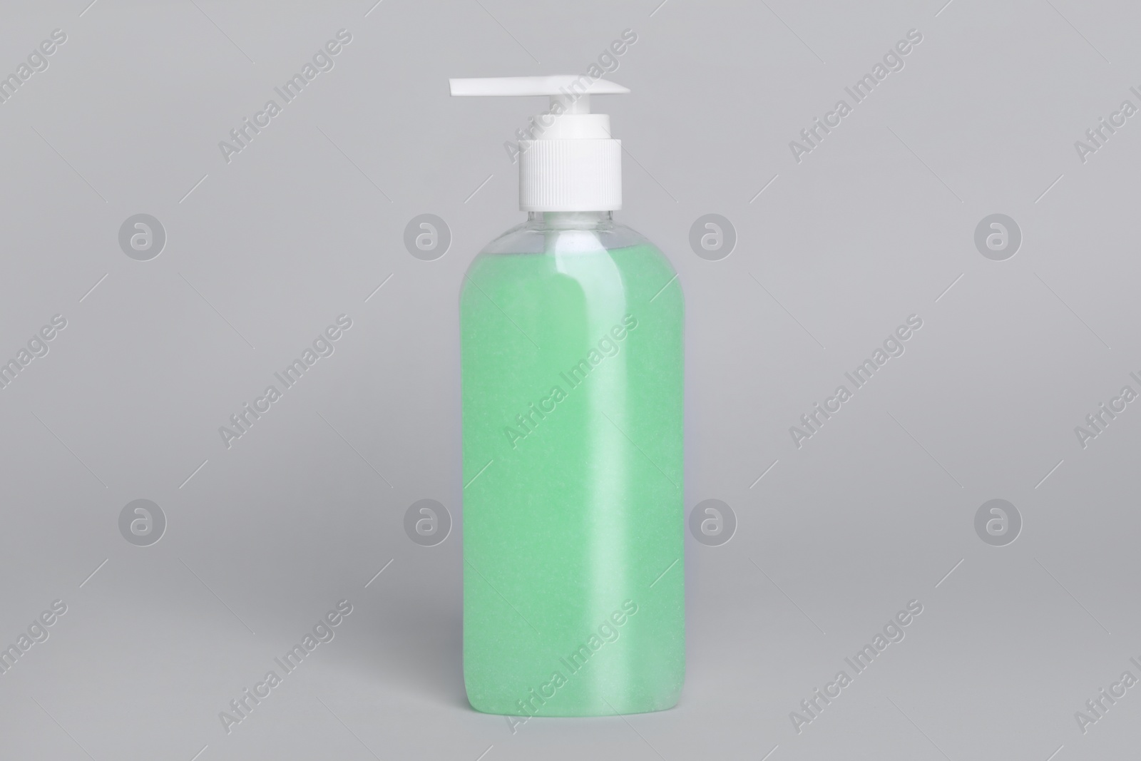 Photo of Bottle of face cleansing product on light grey background. Space for text