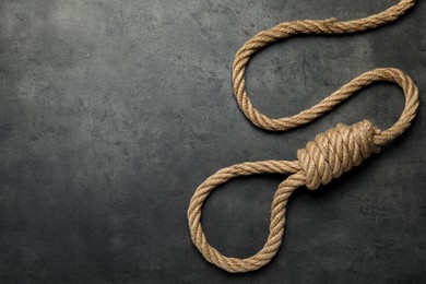 Rope noose with knot on grey table, top view. Space for text