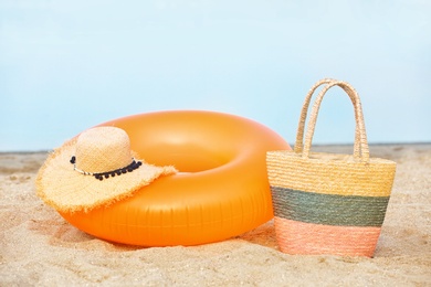 Colorful inflatable ring, hat and bag on sand. Beach object