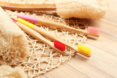 Photo of Natural toothbrushes made with bamboo on wooden table