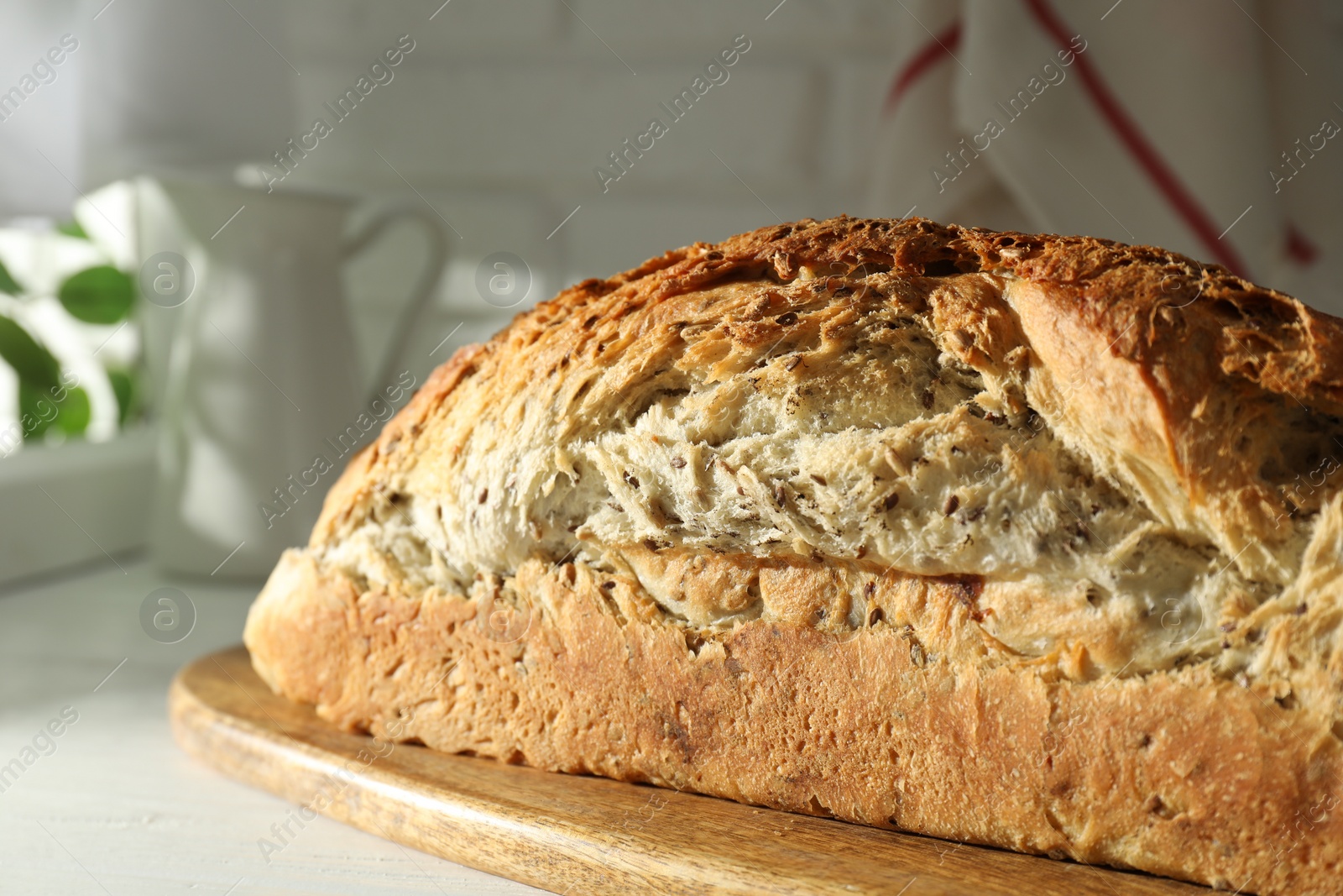 Photo of Freshly baked sourdough bread on white wooden table indoors, closeup