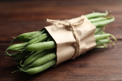 Photo of Fresh green beans on wooden table, closeup