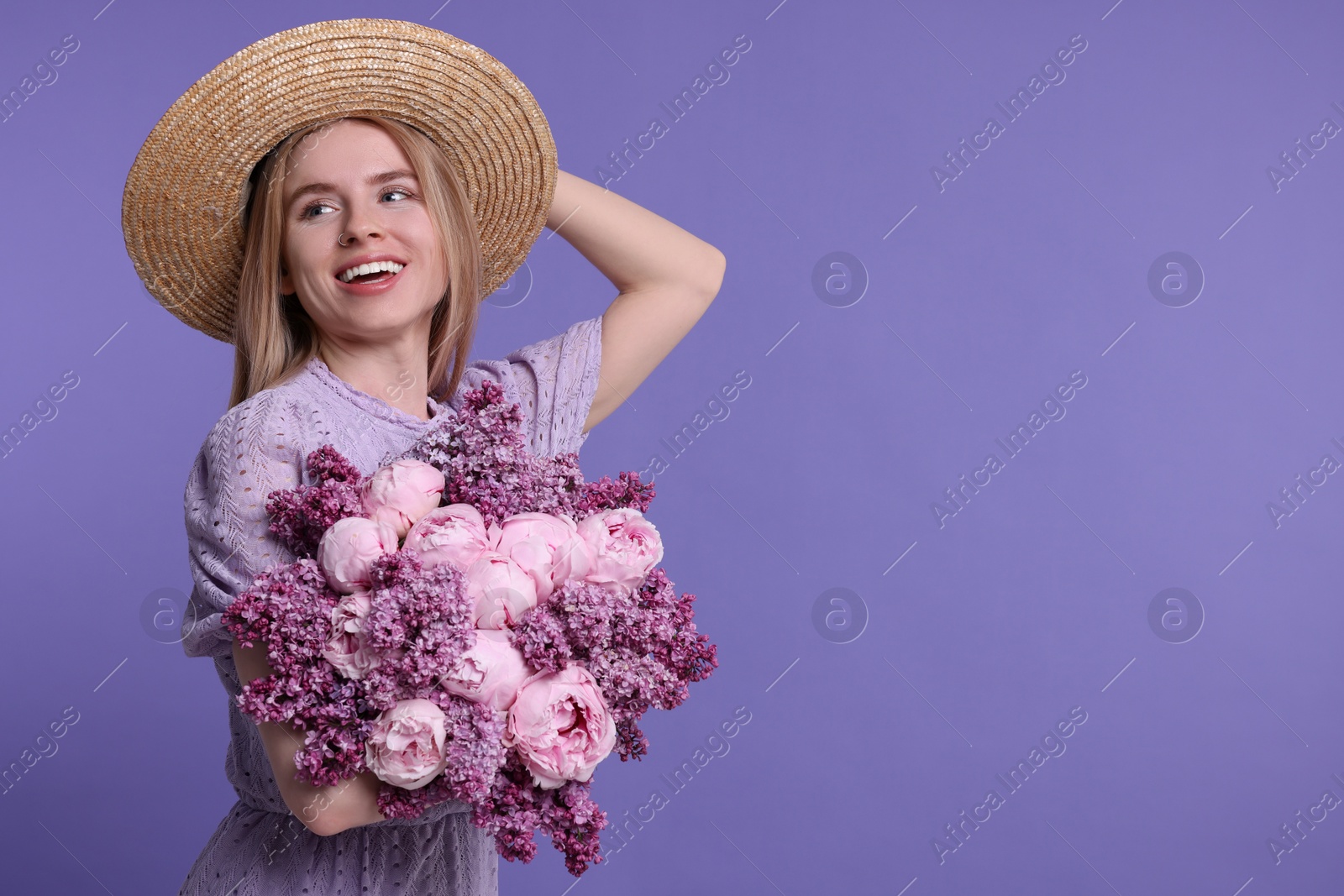 Photo of Beautiful woman with bouquet of spring flowers on purple background, space for text