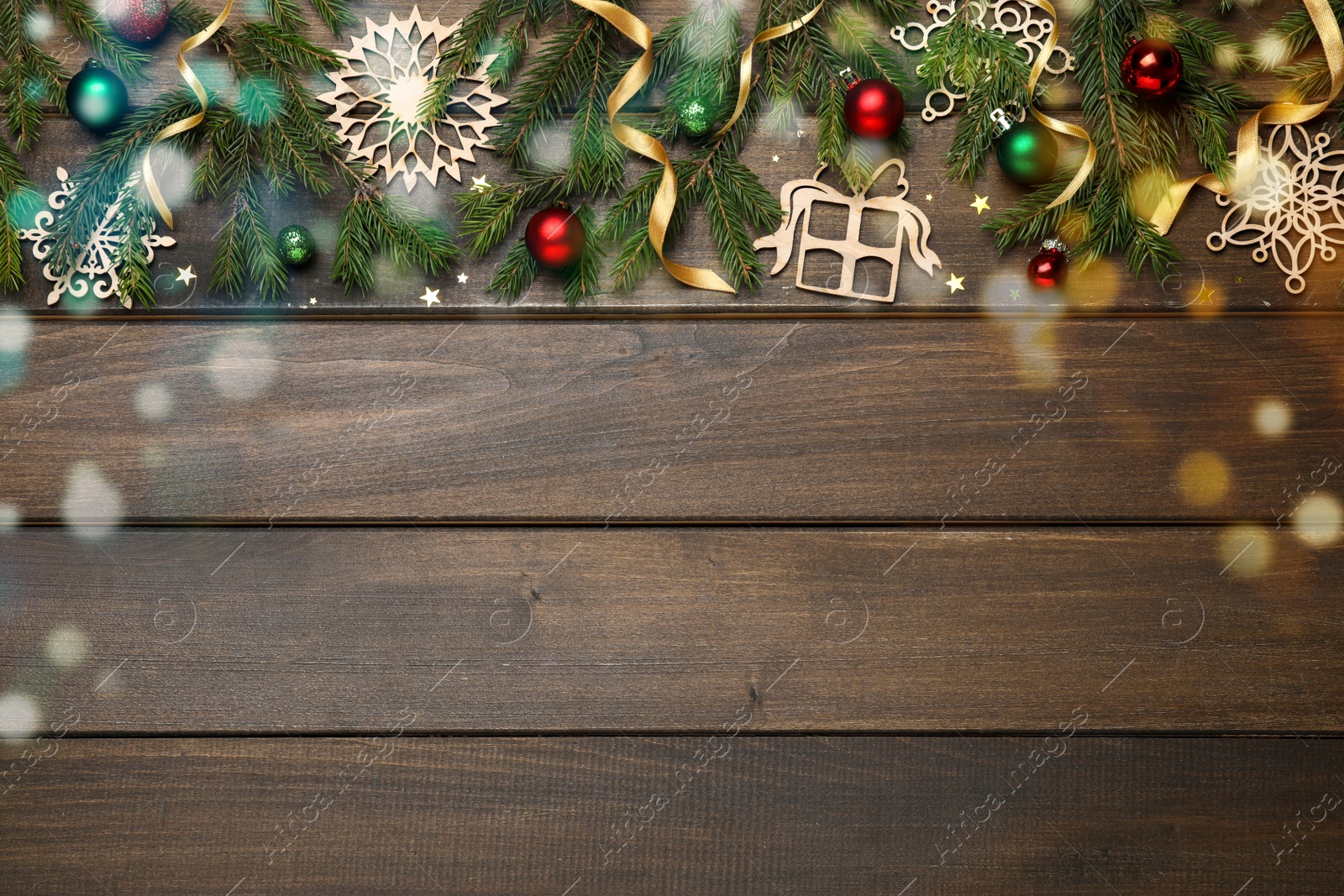 Photo of Christmas greeting card with space for text. Flat lay composition of fir tree branches and festive decor on wooden background