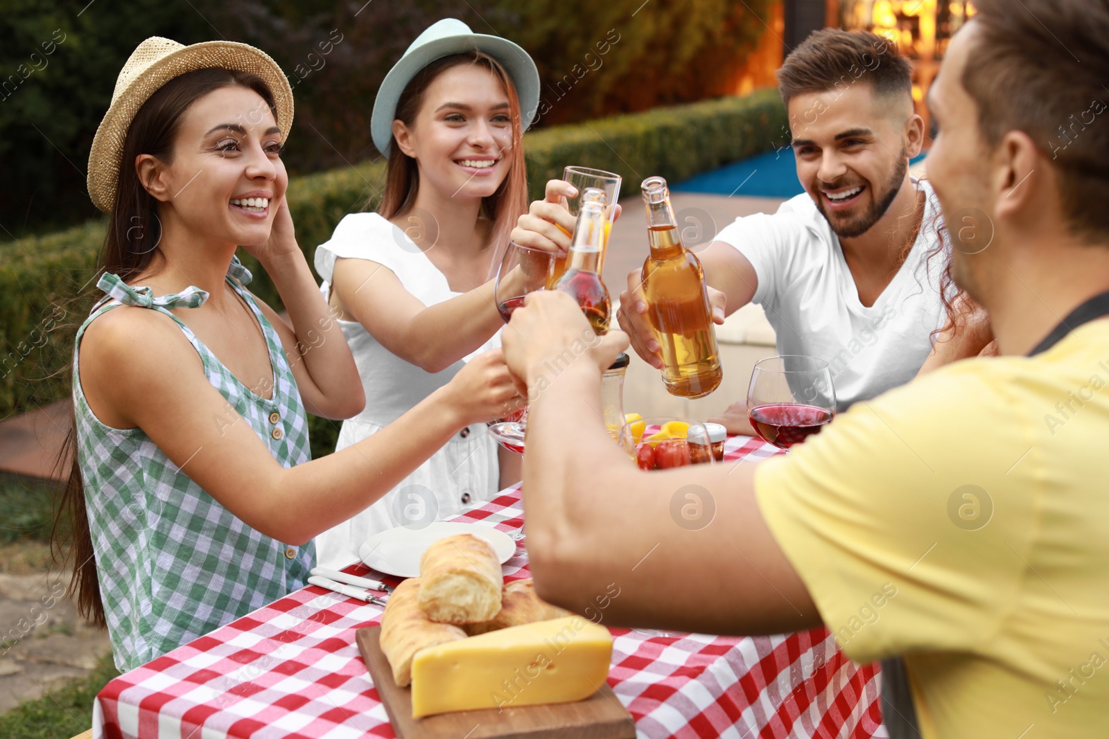 Photo of Happy friends with drinks having fun at barbecue party outdoors