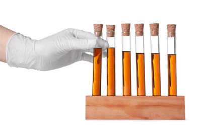 Scientist taking test tube with brown liquid from stand on white background, closeup