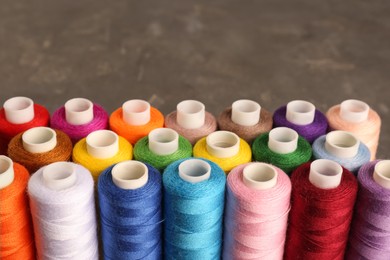 Photo of Set of color sewing threads on grey table