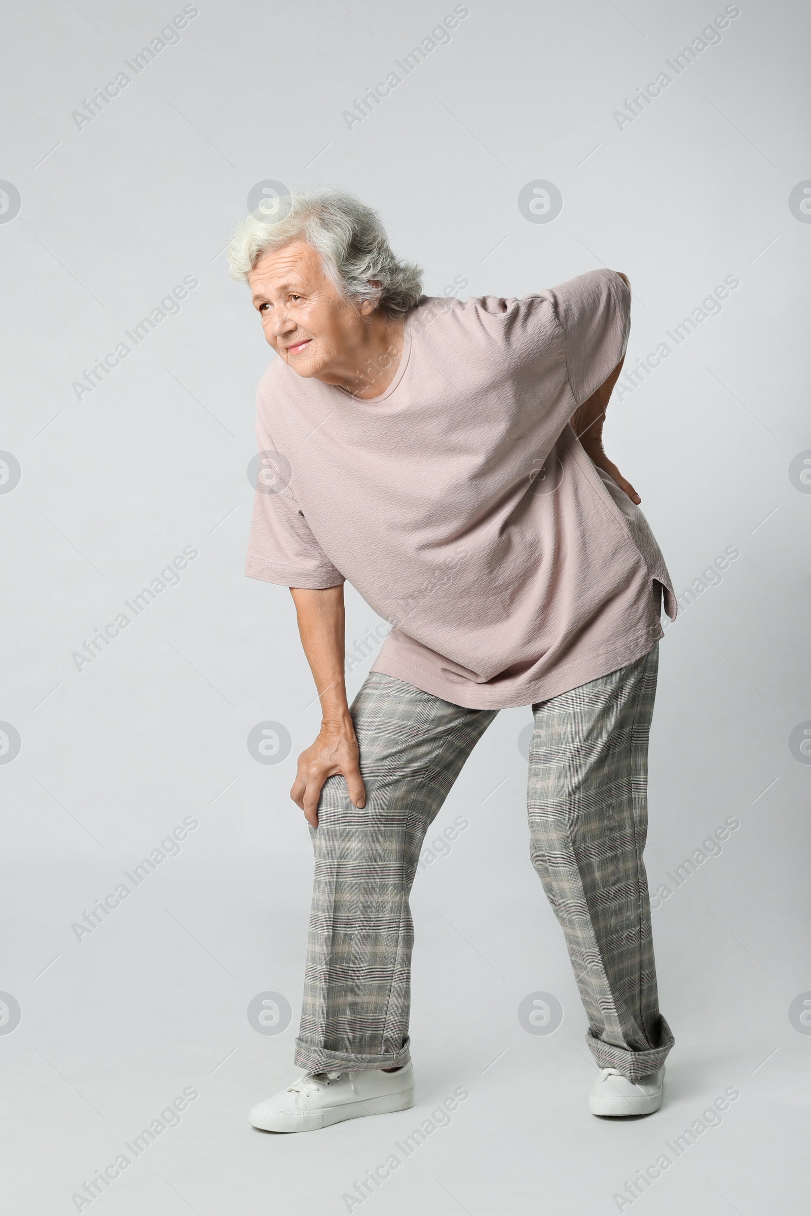 Photo of Full length portrait of senior woman having knee problems on grey background