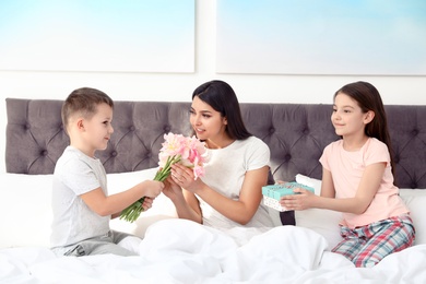 Photo of Son and daughter congratulating mom in bed. Happy Mother's Day
