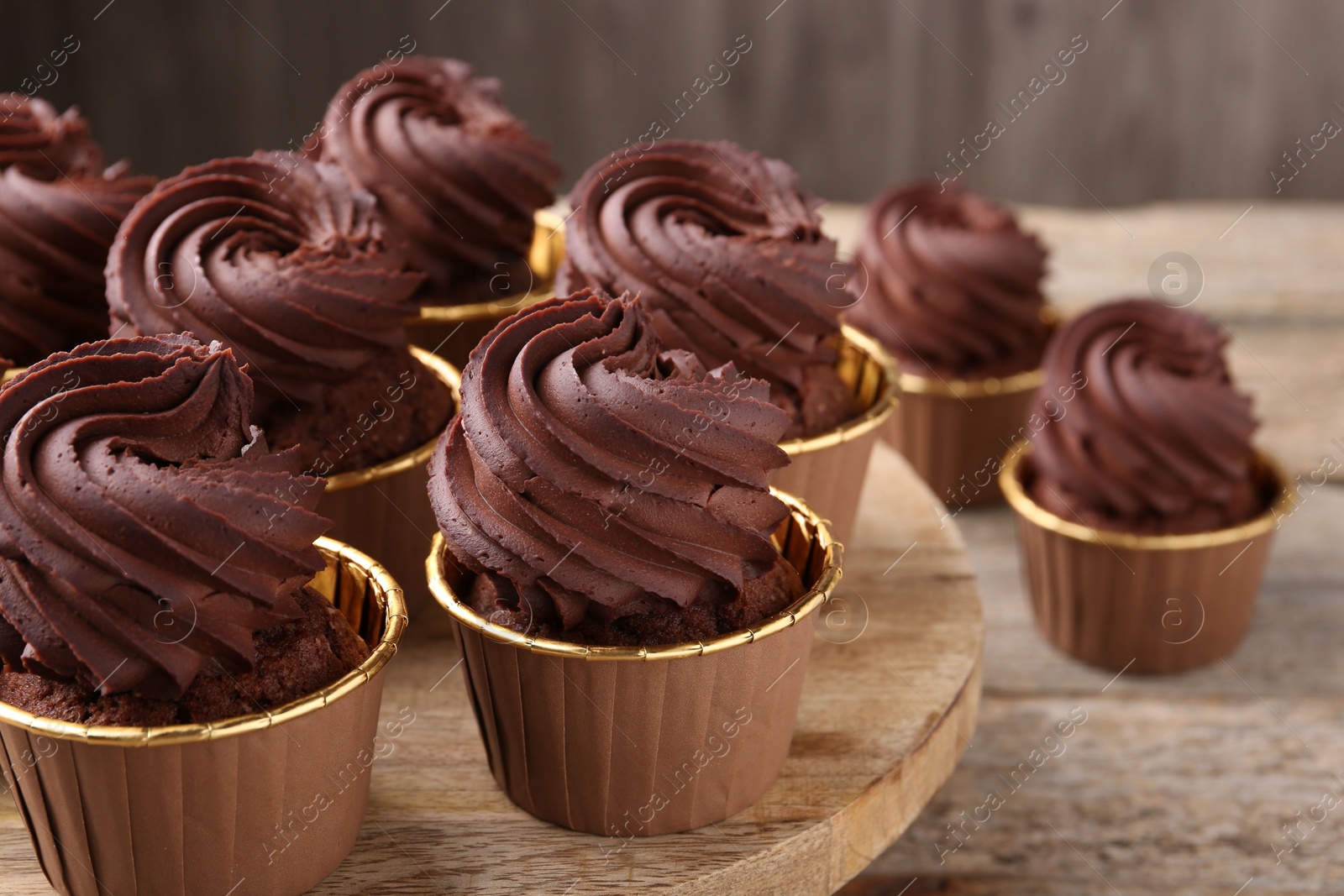 Photo of Delicious chocolate cupcakes on wooden table, closeup