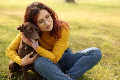 Woman with her cute German Shorthaired Pointer dog in park on spring day