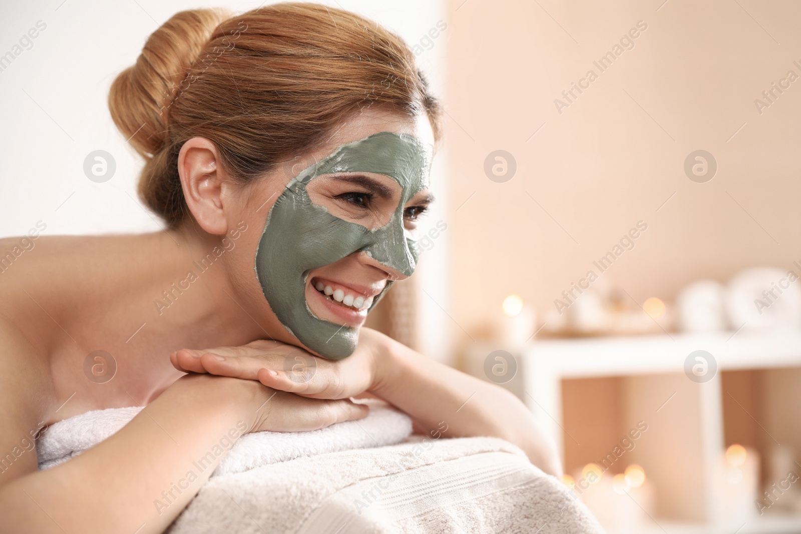 Photo of Beautiful woman with mask on face relaxing in spa salon. Space for text