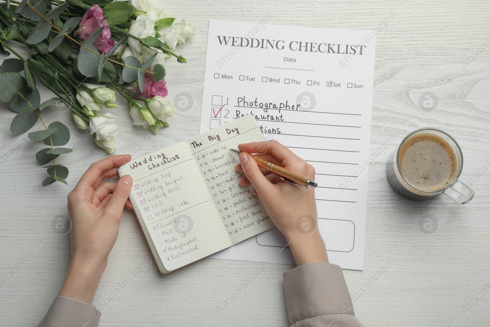 Photo of Woman writing in Wedding Planner at white wooden table, top view