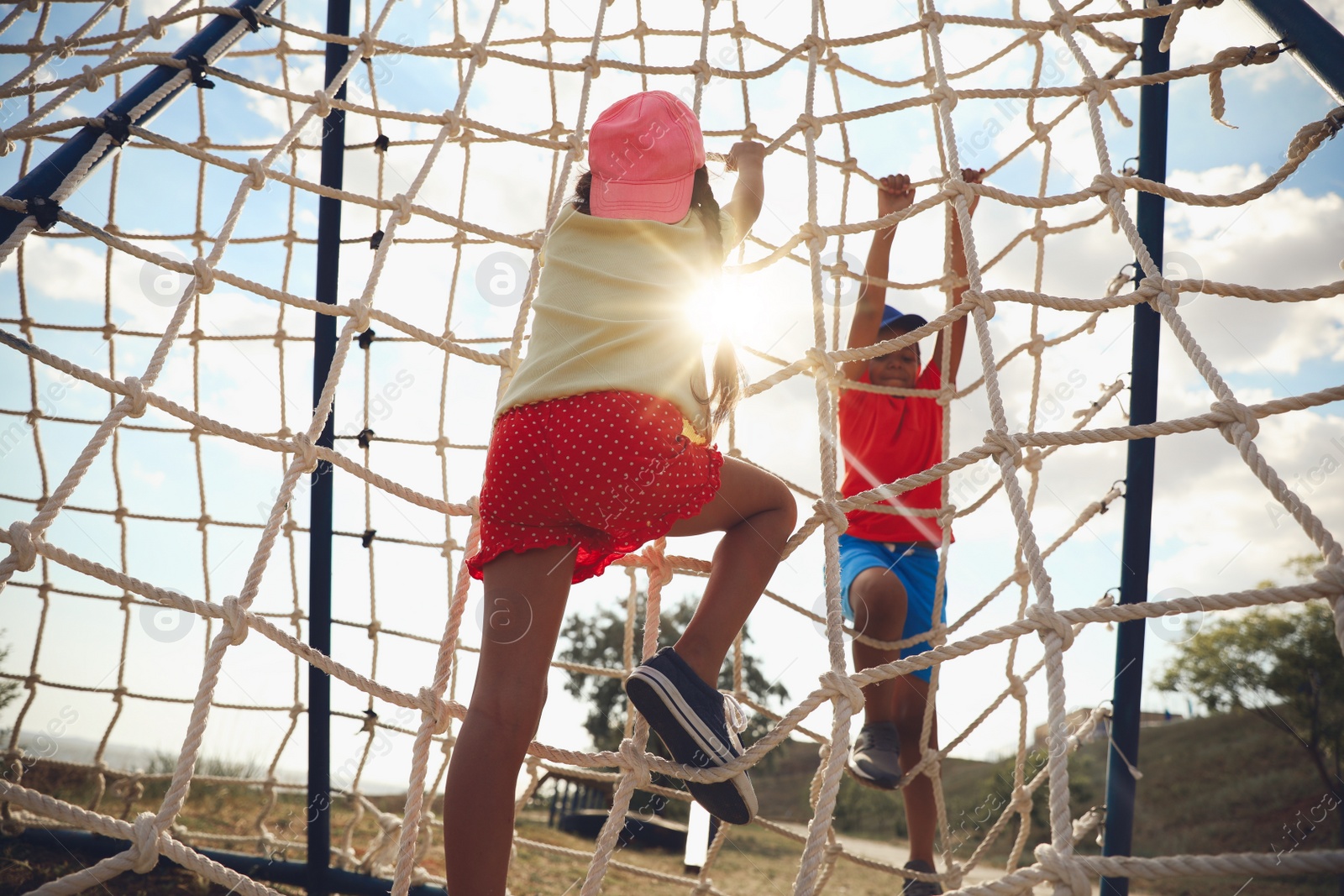 Photo of Cute children on playground rope climber outdoors. Summer camp