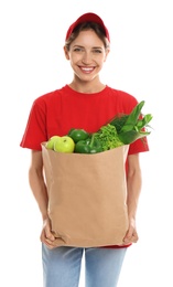 Photo of Delivery woman with bag of fresh vegetables on white background