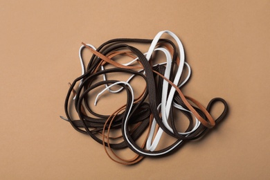 Photo of Different shoelaces on brown background, flat lay