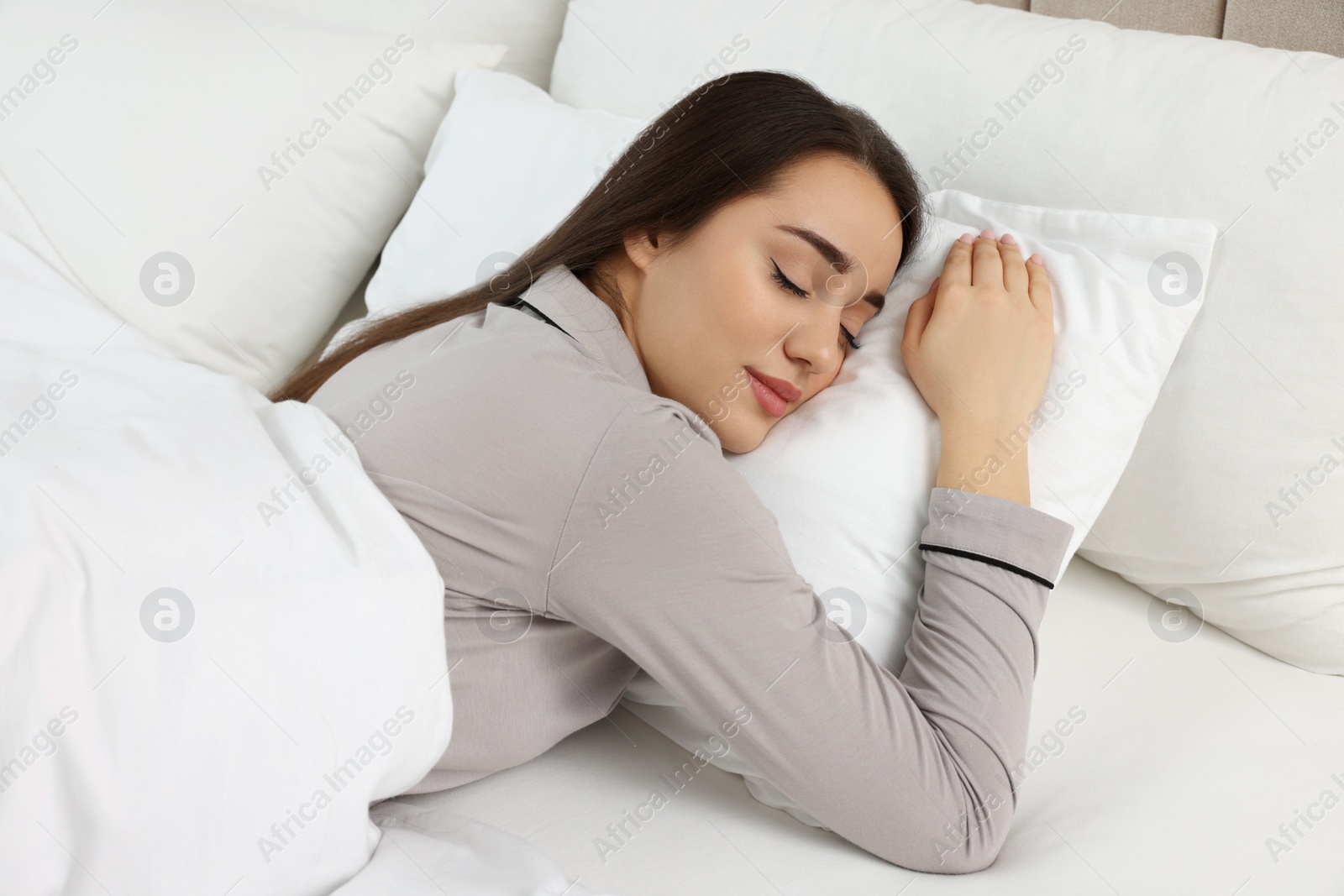 Photo of Beautiful young woman sleeping in soft bed