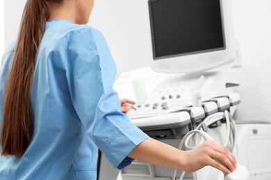 Sonographer operating modern ultrasound machine in clinic, closeup