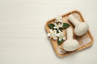 Photo of Beautiful jasmine flowers, herbal bags and sea salt on white wooden table, top view. Space for text