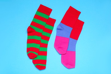 Photo of Different striped socks on light blue background, flat lay