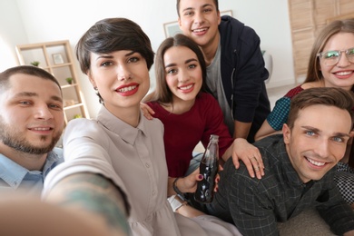 Happy friends taking selfie indoors
