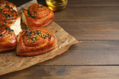 Traditional Ukrainian bread (Pampushky) with garlic on wooden table, space for text