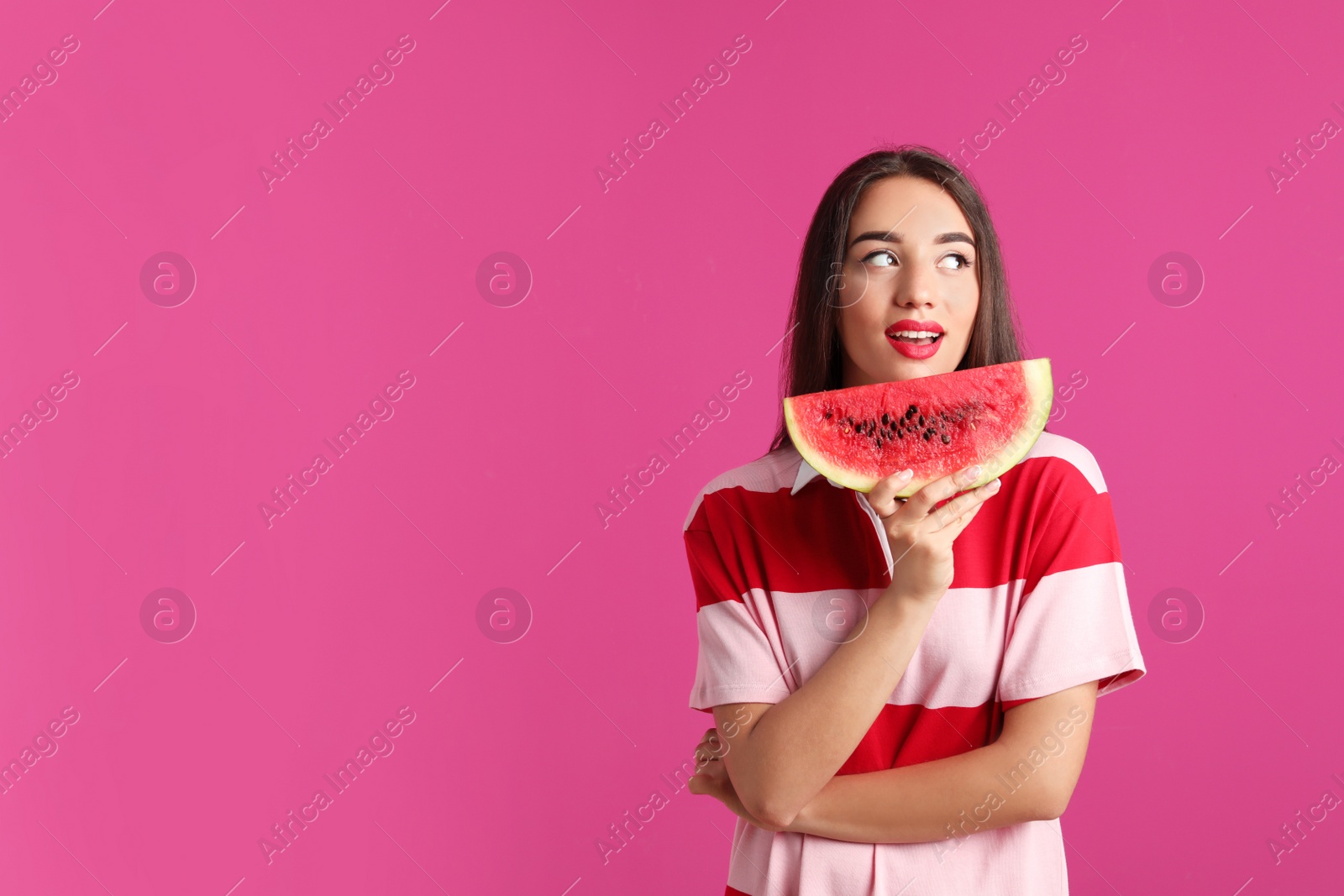 Photo of Beautiful young woman posing with watermelon on color background