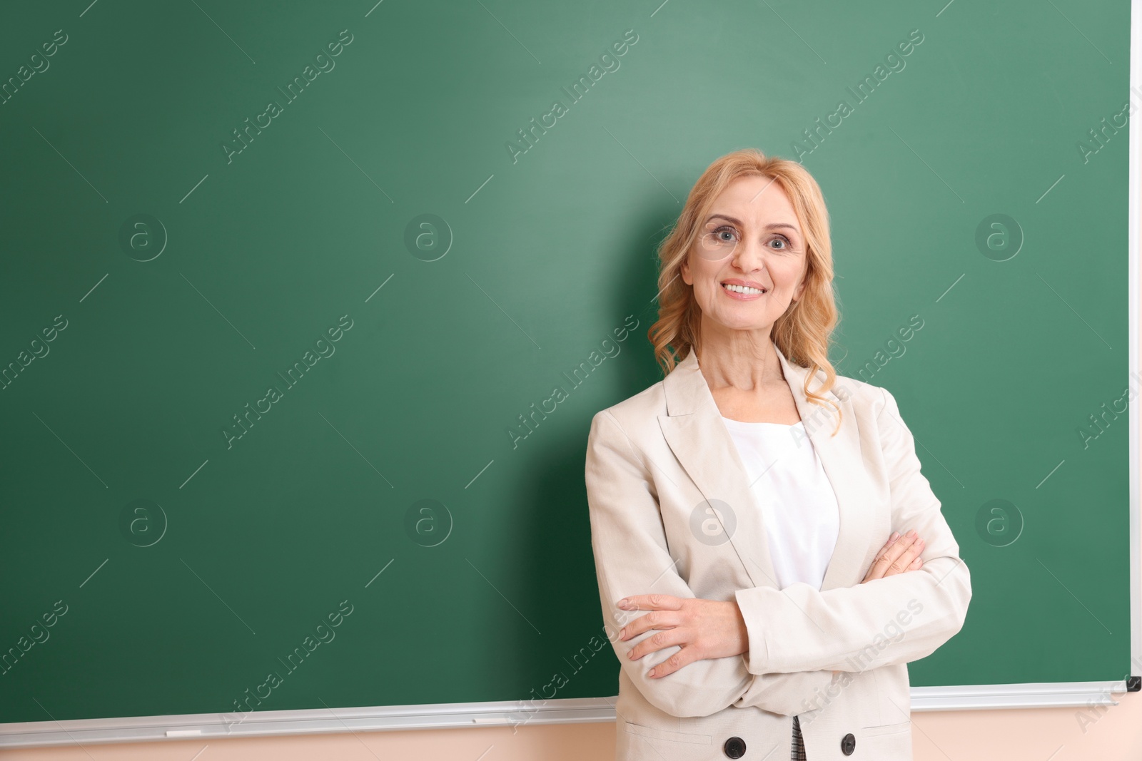 Photo of Happy professor near empty green board, space for text