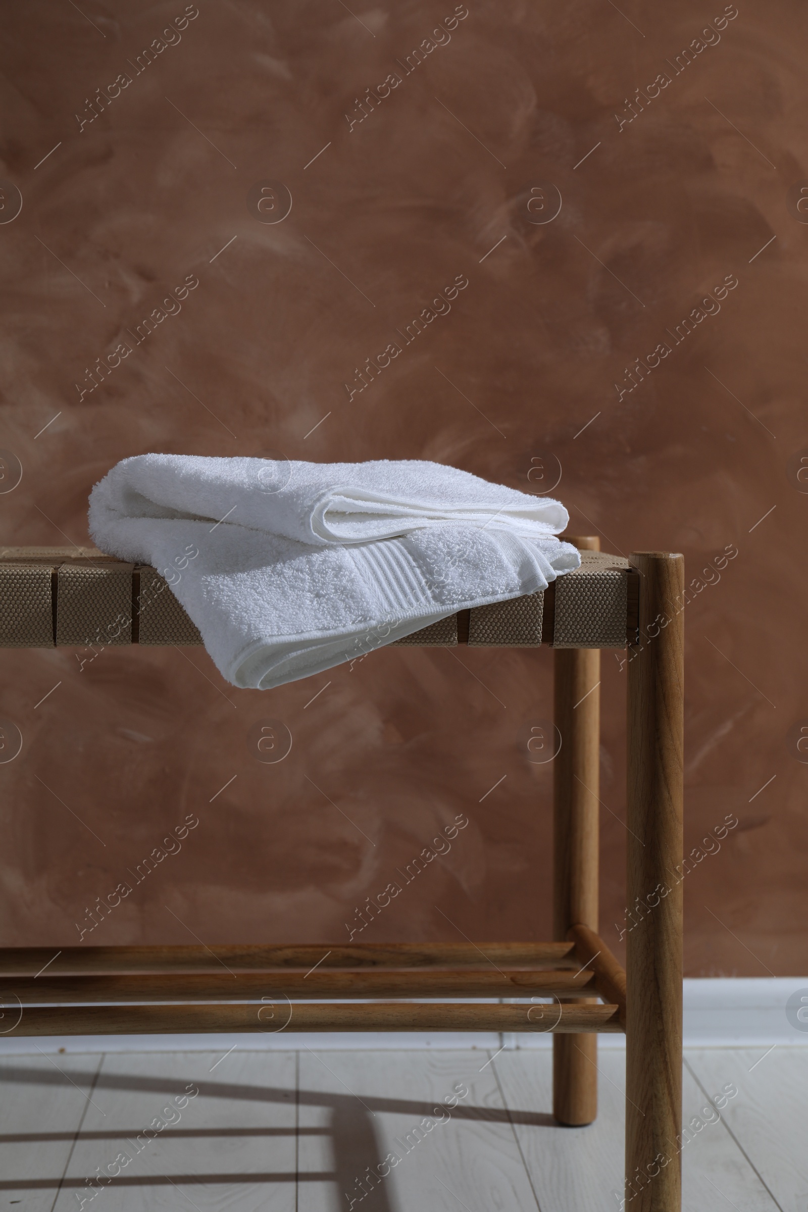 Photo of Clean towel on table against brown background